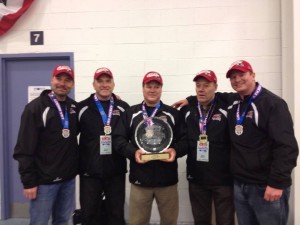 The 18U Ice Bears coaching staff poses with the spoils.