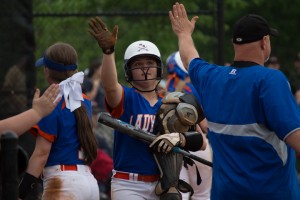 Amanda Coffey gets a no-look high five from a Lady Governor assistant after plating the go-ahead run.
